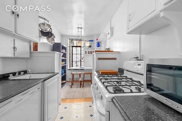 kitchen featuring white cabinets, white appliances, and light tile patterned floors