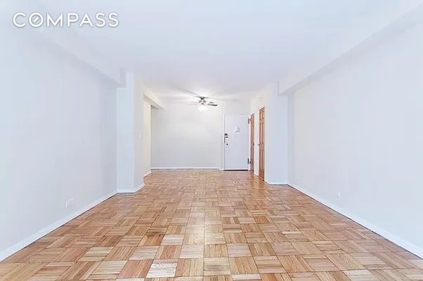 spare room with light parquet floors and ceiling fan