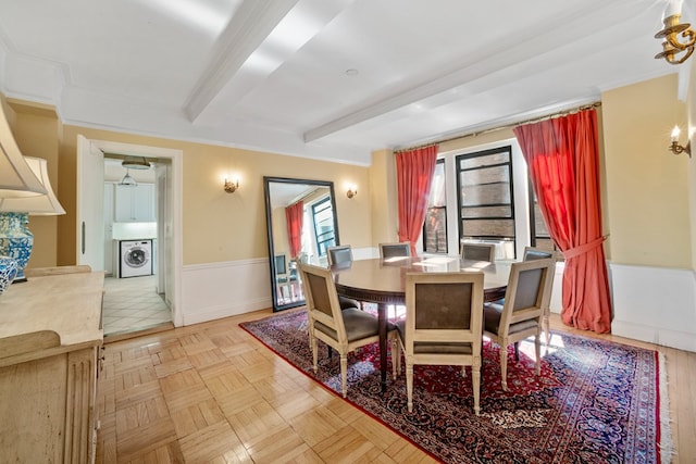 dining room featuring beamed ceiling, ornamental molding, washer / clothes dryer, and light parquet floors