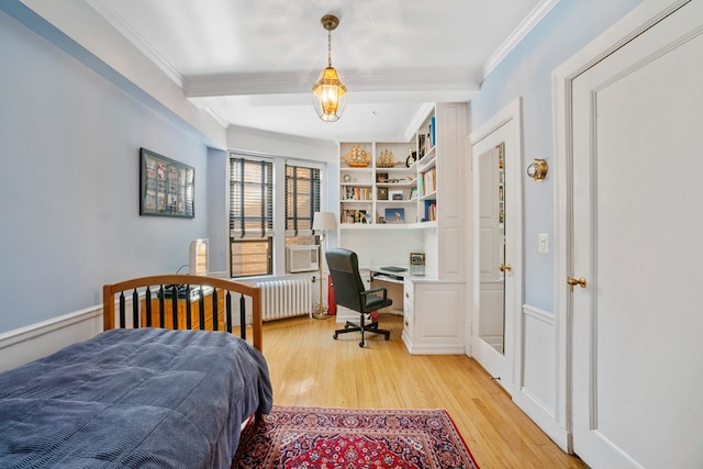 bedroom with light hardwood / wood-style floors, crown molding, and radiator