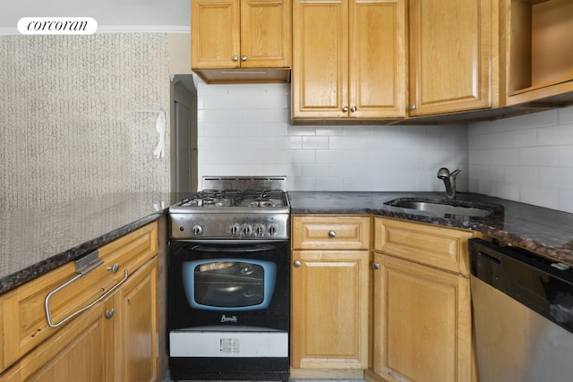 kitchen featuring sink, gas range oven, dishwasher, and dark stone counters