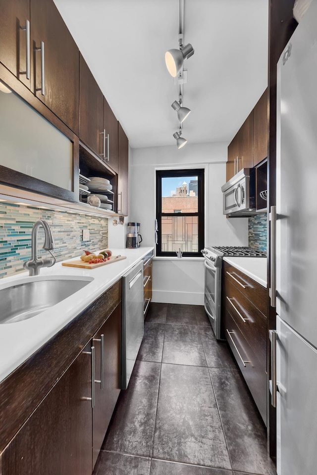 kitchen with sink, appliances with stainless steel finishes, dark brown cabinetry, and tasteful backsplash