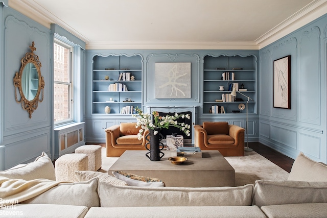 sitting room featuring crown molding, wood-type flooring, and built in features