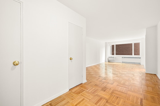 unfurnished room with light parquet flooring and radiator heating unit