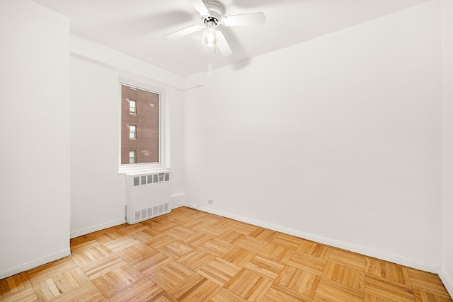 unfurnished room with light parquet flooring, radiator, and ceiling fan