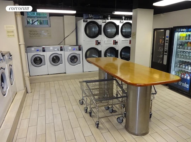 clothes washing area with light hardwood / wood-style flooring, washing machine and clothes dryer, beverage cooler, and stacked washing maching and dryer