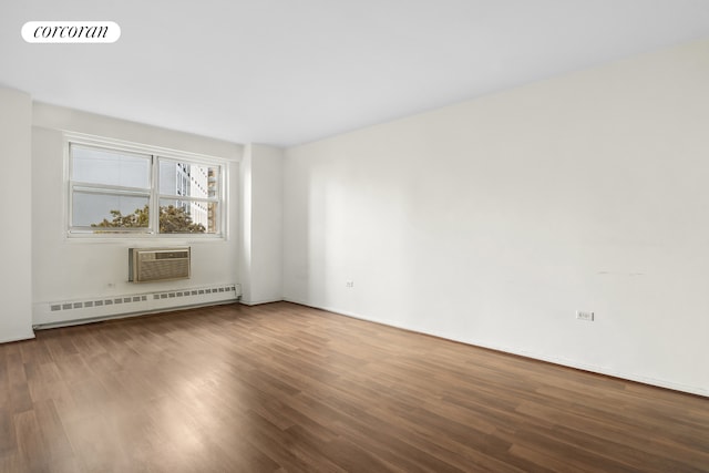 unfurnished living room featuring a wall mounted AC, hardwood / wood-style floors, and a baseboard heating unit