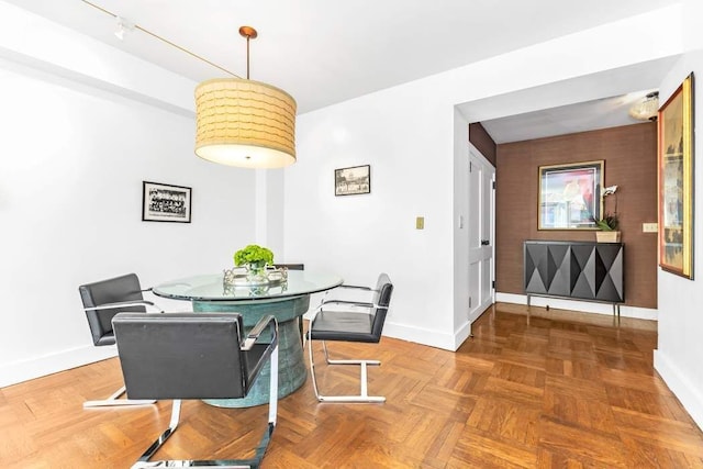 dining space with parquet flooring