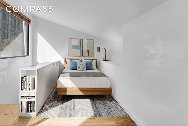 bedroom with lofted ceiling and hardwood / wood-style flooring