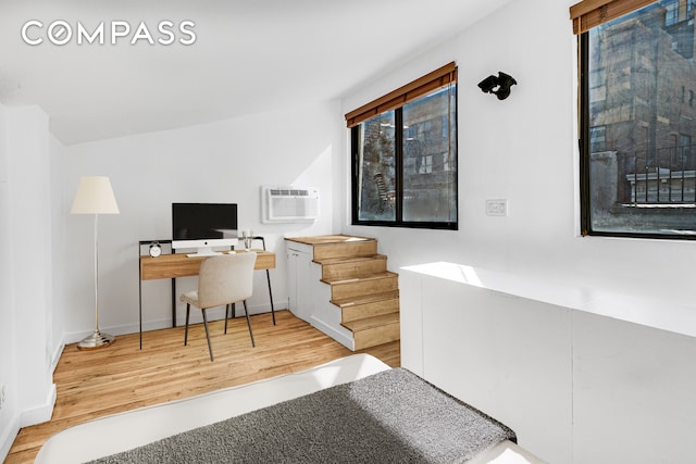 office featuring an AC wall unit and light hardwood / wood-style floors