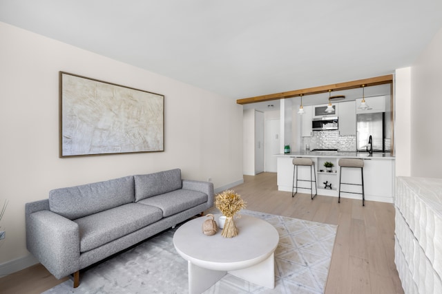 living room with light hardwood / wood-style floors and sink