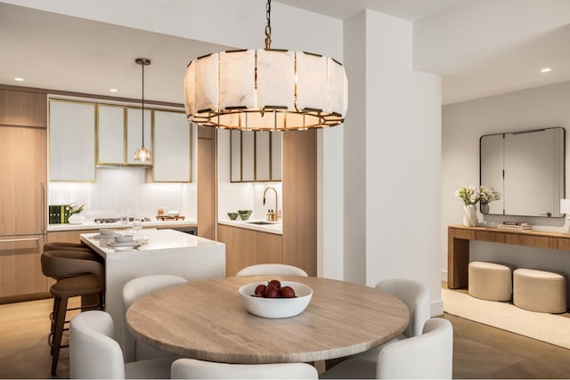 dining space with sink and light parquet flooring