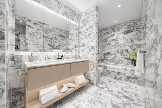 bathroom with vanity, a shower with door, toilet, and tile walls