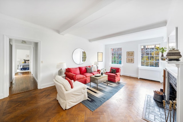 living room featuring a brick fireplace, beam ceiling, and dark parquet floors