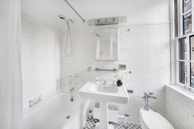 bathroom featuring tile walls, radiator heating unit, toilet, and shower / tub combo with curtain