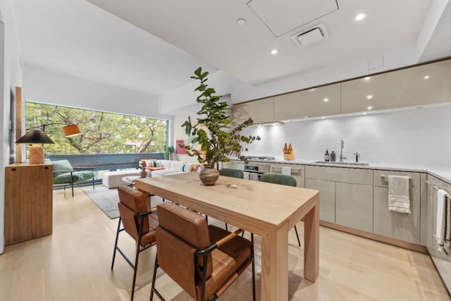 kitchen with light hardwood / wood-style floors, sink, and backsplash