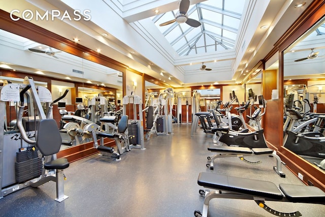 workout area featuring ceiling fan, a skylight, and ornamental molding