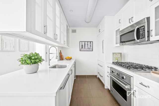 kitchen featuring white cabinetry, appliances with stainless steel finishes, sink, and backsplash