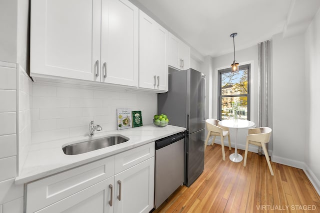 kitchen featuring backsplash, stainless steel appliances, white cabinetry, and sink