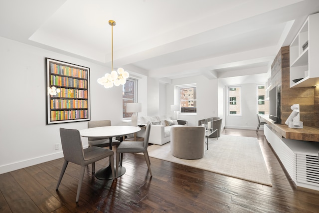 dining room featuring a raised ceiling, dark hardwood / wood-style flooring, and an inviting chandelier