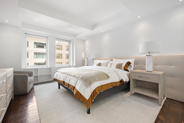 bedroom featuring dark hardwood / wood-style flooring and a raised ceiling