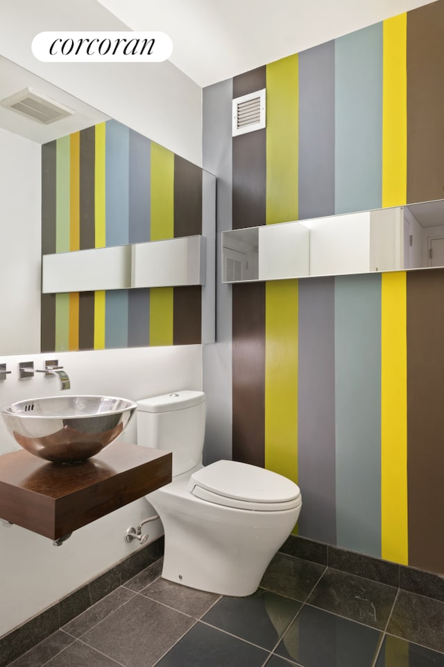 bathroom featuring toilet, sink, and tile patterned floors