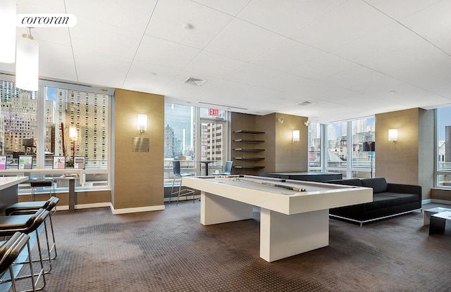 game room featuring a wall of windows and dark carpet