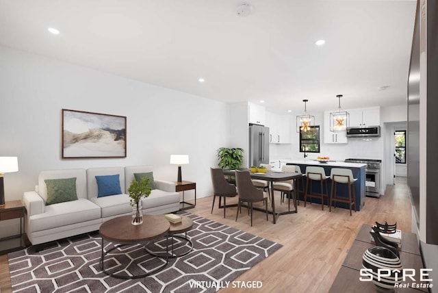 living room with light wood-type flooring and sink