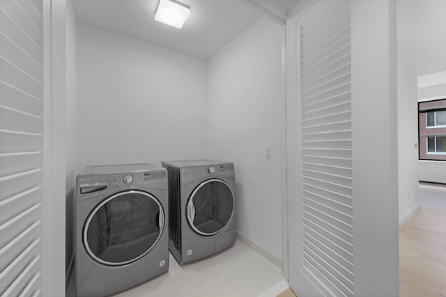 laundry area with light wood-type flooring and washing machine and dryer