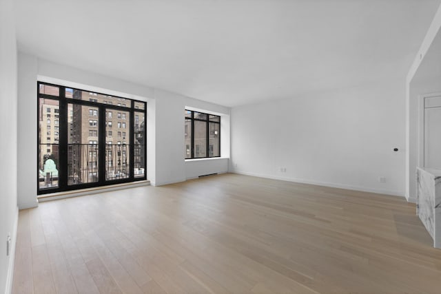 unfurnished room with light wood-type flooring