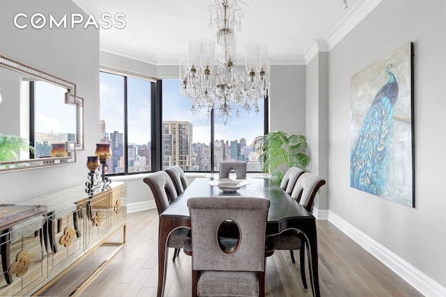 dining area with an inviting chandelier, wood-type flooring, and ornamental molding