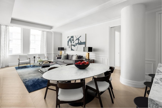 dining space with light parquet floors and decorative columns