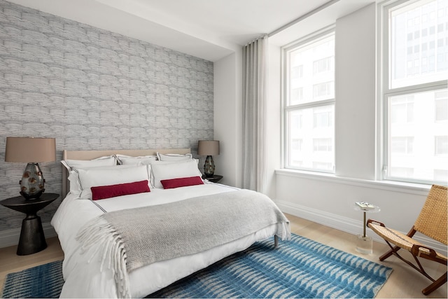 bedroom with light wood-type flooring and multiple windows