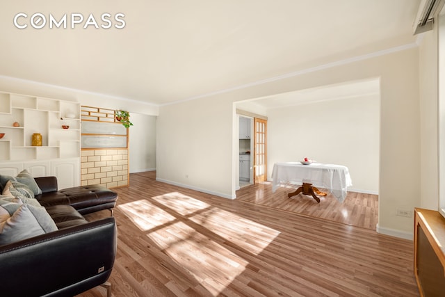 living room with light hardwood / wood-style floors and crown molding