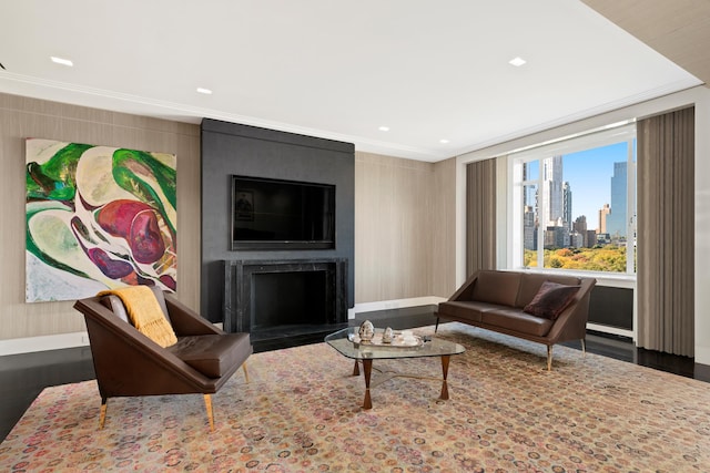 living room featuring hardwood / wood-style floors, crown molding, and a fireplace