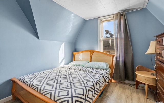 bedroom featuring lofted ceiling and light hardwood / wood-style flooring