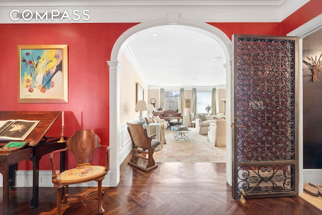 hallway featuring ornate columns, parquet flooring, and ornamental molding