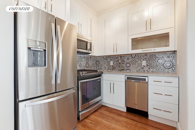 kitchen featuring white cabinets, sink, decorative backsplash, light hardwood / wood-style floors, and stainless steel appliances