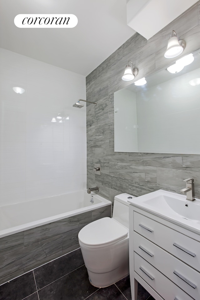 full bathroom with tile patterned floors, tiled shower / bath, tile walls, and toilet