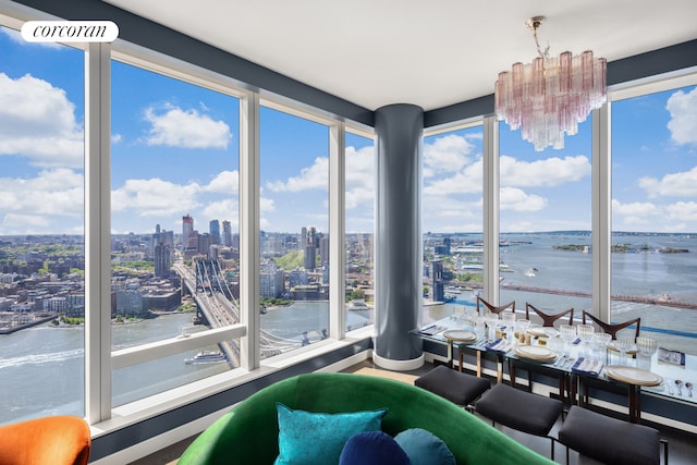 unfurnished sunroom featuring a notable chandelier and a water view