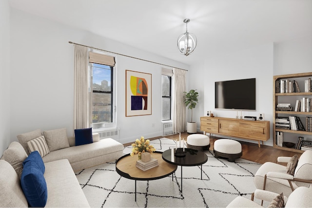 living room with light hardwood / wood-style floors and a notable chandelier