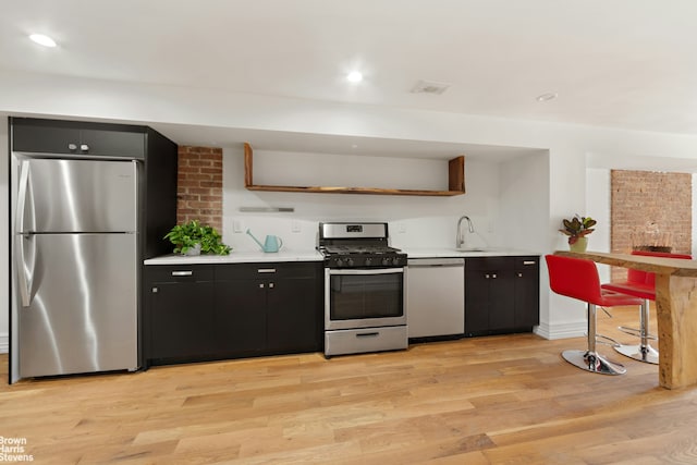 kitchen featuring stainless steel appliances, light hardwood / wood-style flooring, and sink