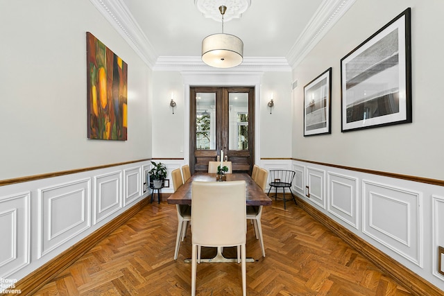 dining space with dark parquet flooring and ornamental molding