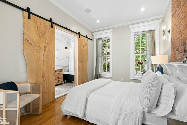 bedroom featuring wood-type flooring, ensuite bathroom, and crown molding