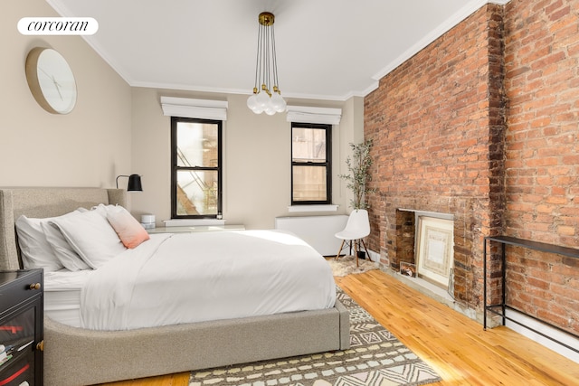 bedroom with wood-type flooring, crown molding, and brick wall