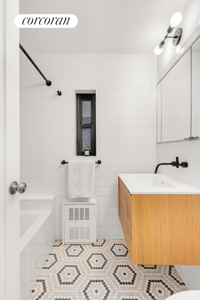 bathroom featuring shower / bath combination, radiator, vanity, tile walls, and tile patterned flooring