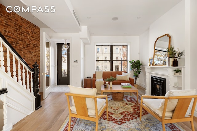 living room featuring light wood-type flooring and brick wall