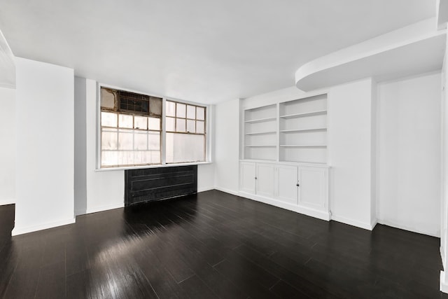 unfurnished living room with dark hardwood / wood-style flooring and radiator heating unit