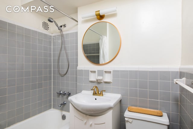 full bathroom featuring shower / bath combo, vanity, tile walls, and toilet