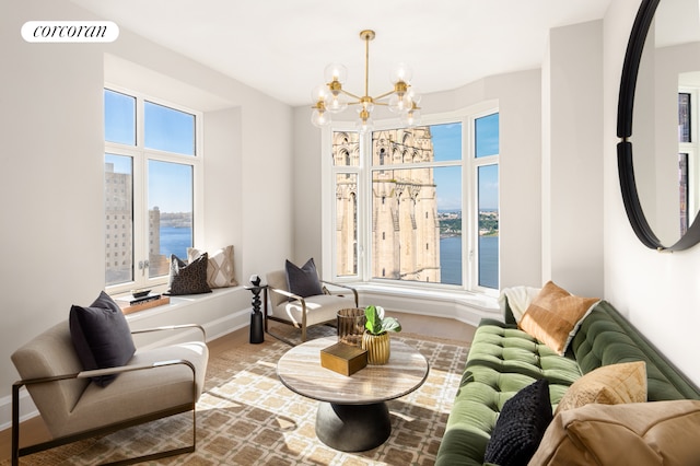 living area featuring hardwood / wood-style floors, a notable chandelier, a healthy amount of sunlight, and a water view